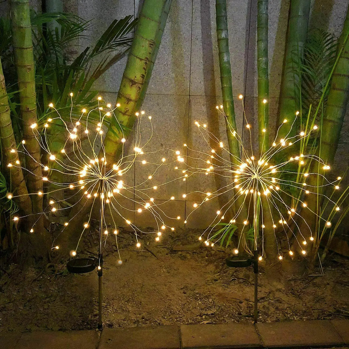 Warm white solar starburst lights shaped for an outdoor garden display; three lights included per set.